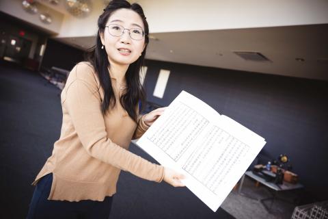 Wandi Wang holds a copy of Pure Offering in the Mountains cookbook